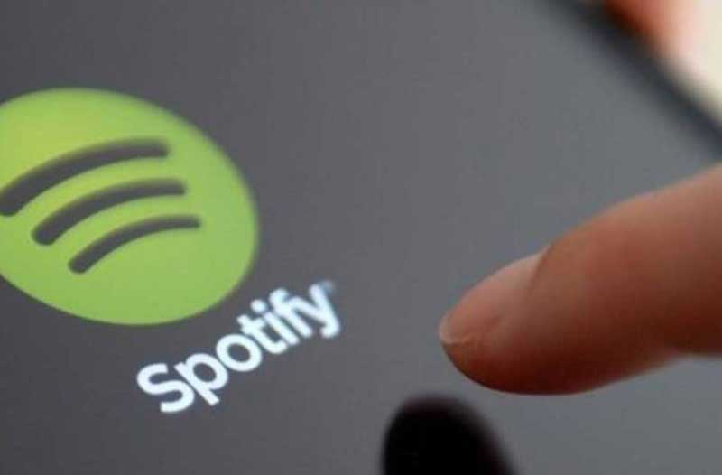 Finger touching Spotify app icon