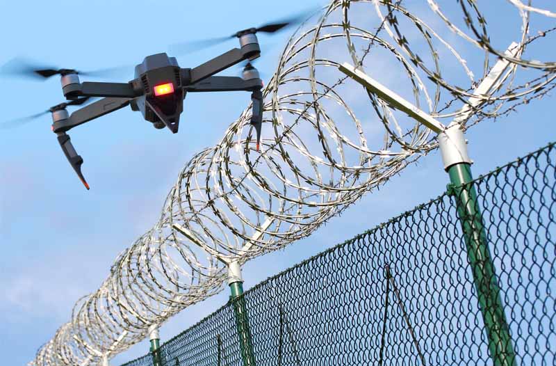 Drone flying over a barbed-wire fence
