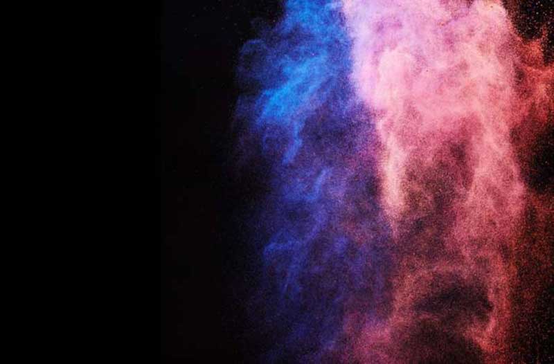 Pink and blue dust floating on a black background