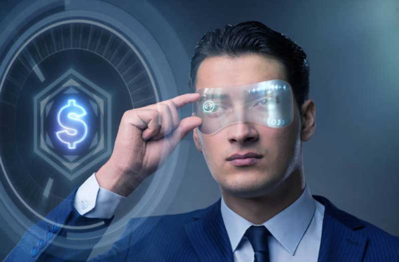A man in a suit wearing futuristic glasses interacts with a holographic display