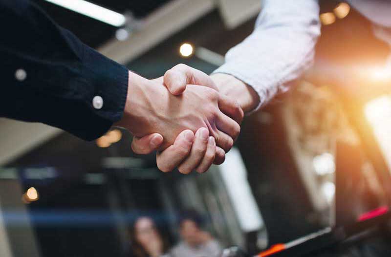 Two men shaking hands at office