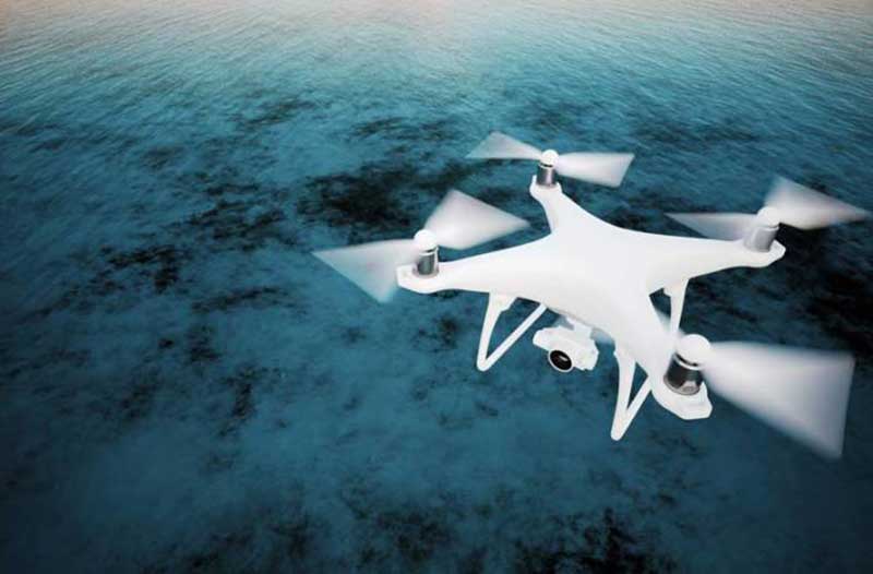 White drone flying above water