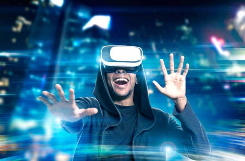 A man in a black hoodie wearing a VR headset and being amazed