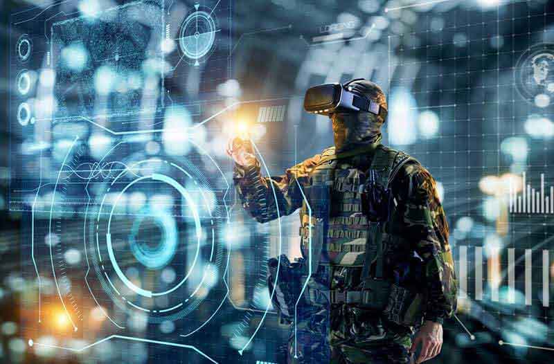 Man in militaire uitrusting en met een VR headset op kijkt naar digitaal scherm