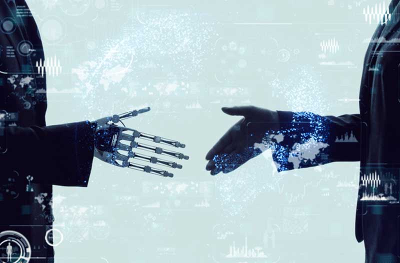 A robot in a suit and a man in a suit about to shake hands