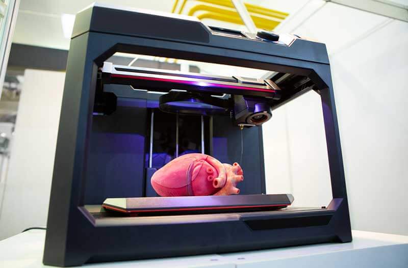 Bioprinter with glass walls and pink human heart inside
