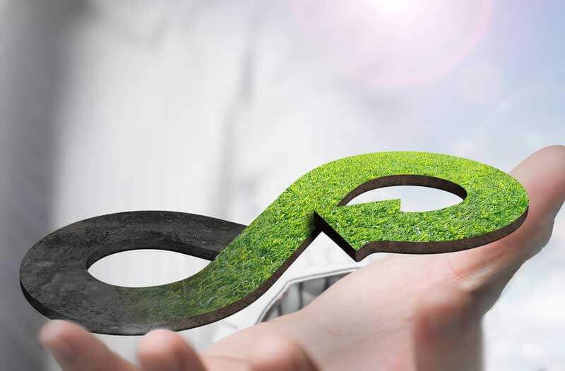 Hand holding green circular economy symbol