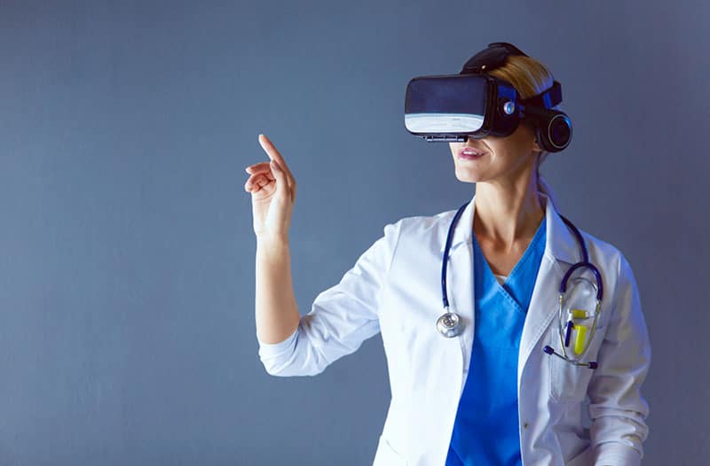 A woman in a lab coat wearing a VR headset.