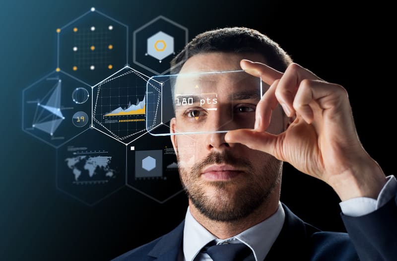 Man in suit holding a virtual smartphone with digital infographics floating in the background